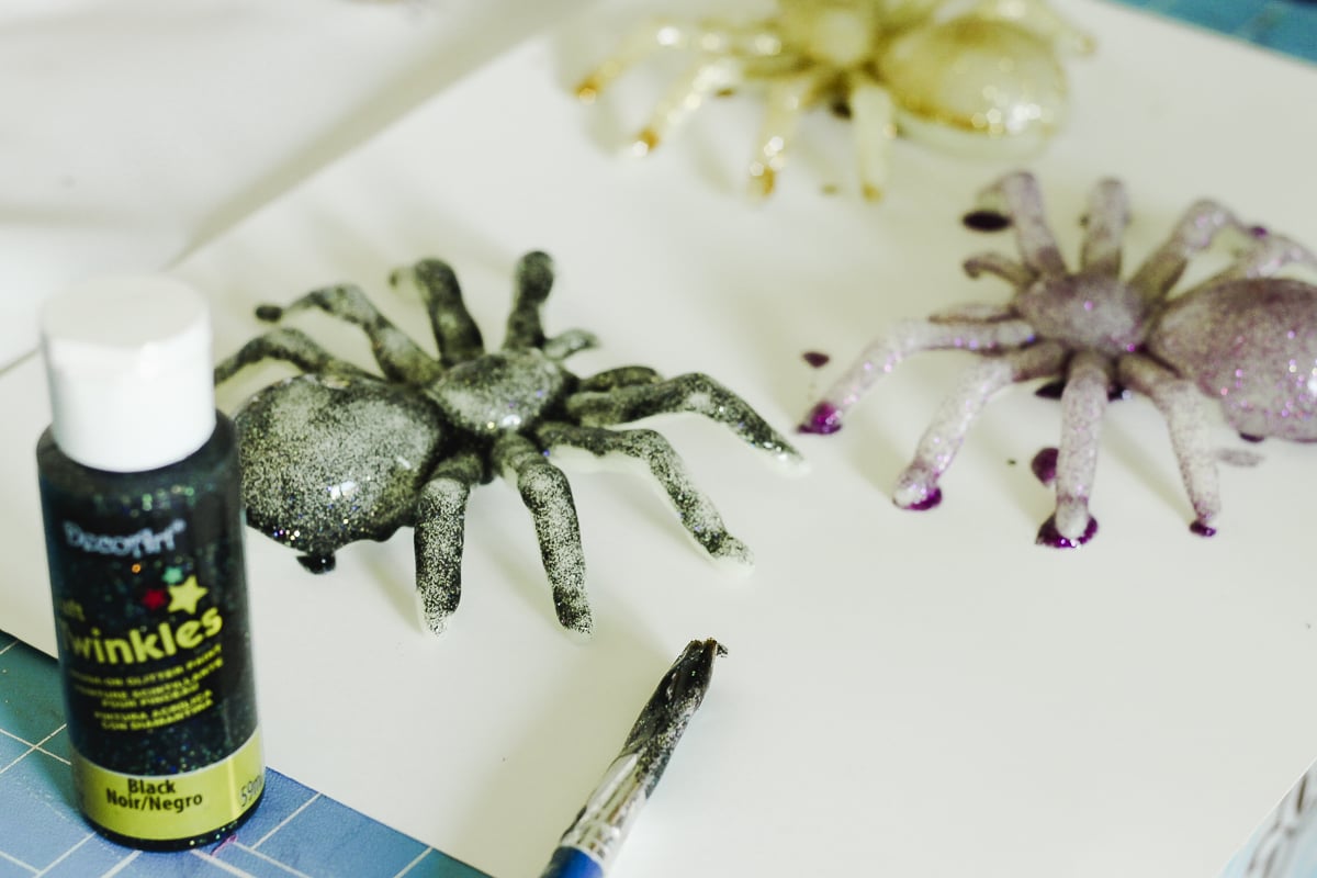 painting plastic spiders with glitter paint