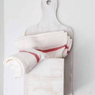 tea towels in a kitchen organizer hanging on a wall