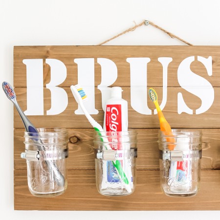 organizer decor for a bathroom with mason jars and a Cricut machine