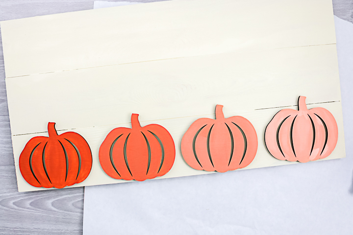 Painted pumpkins attached to pallet sign