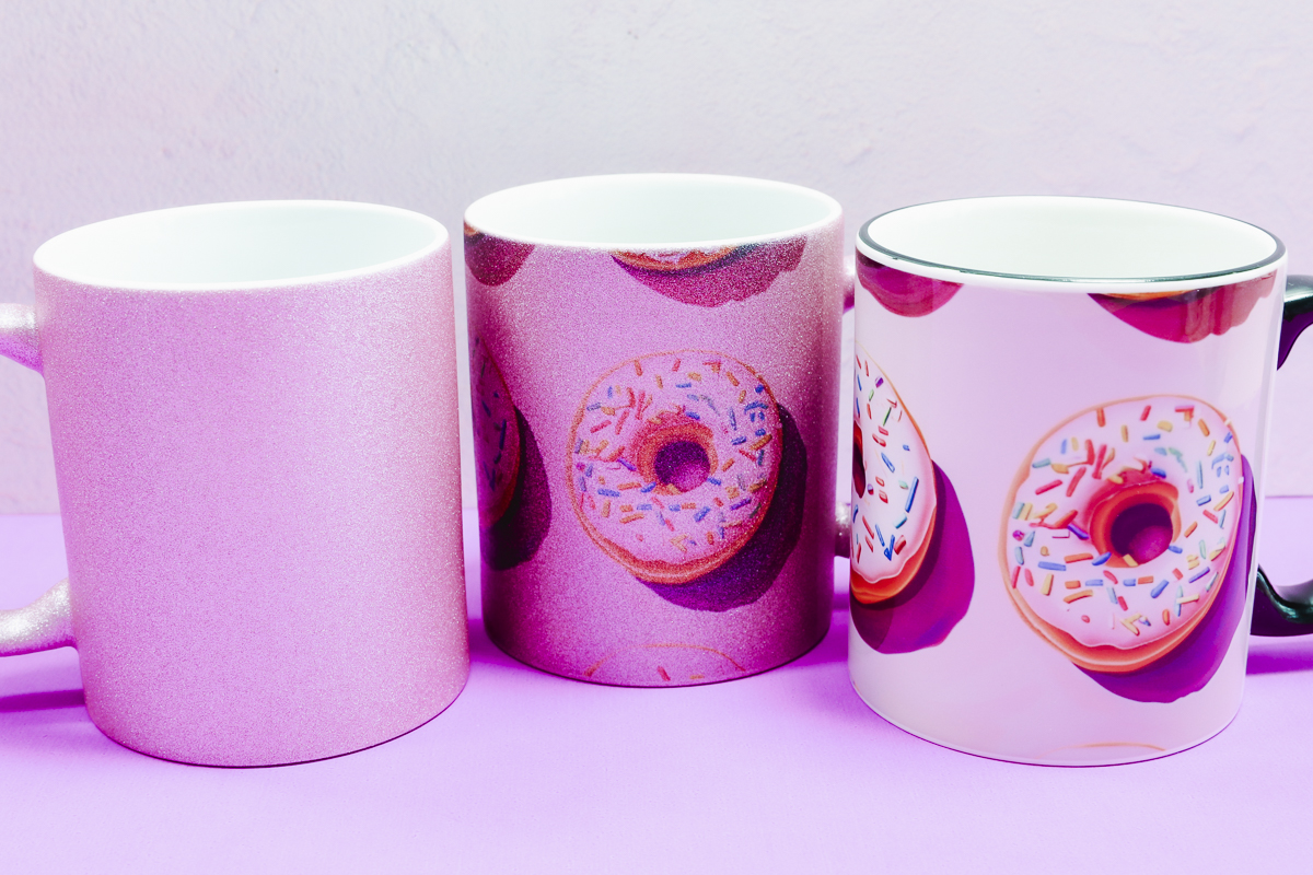 Pink glitter sublimation mug and black handle mug with donut sublimation print.