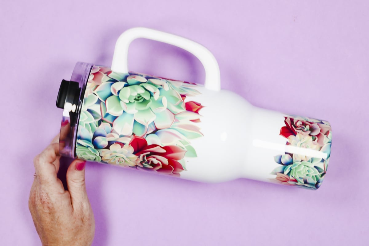 Sublimation tumbler with attached handle.